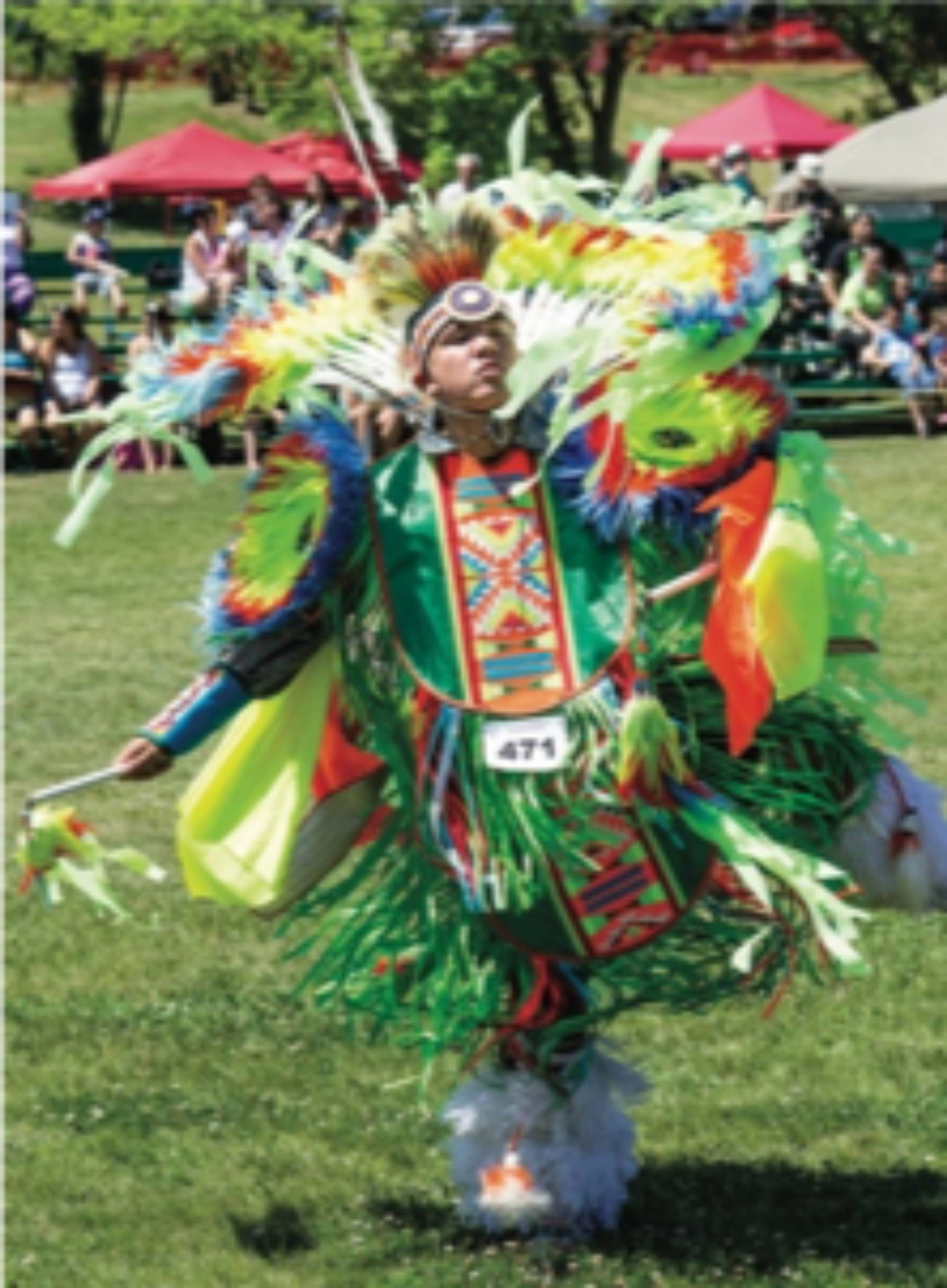 Man dancing wearing fancy regalia at a Pow Wow
